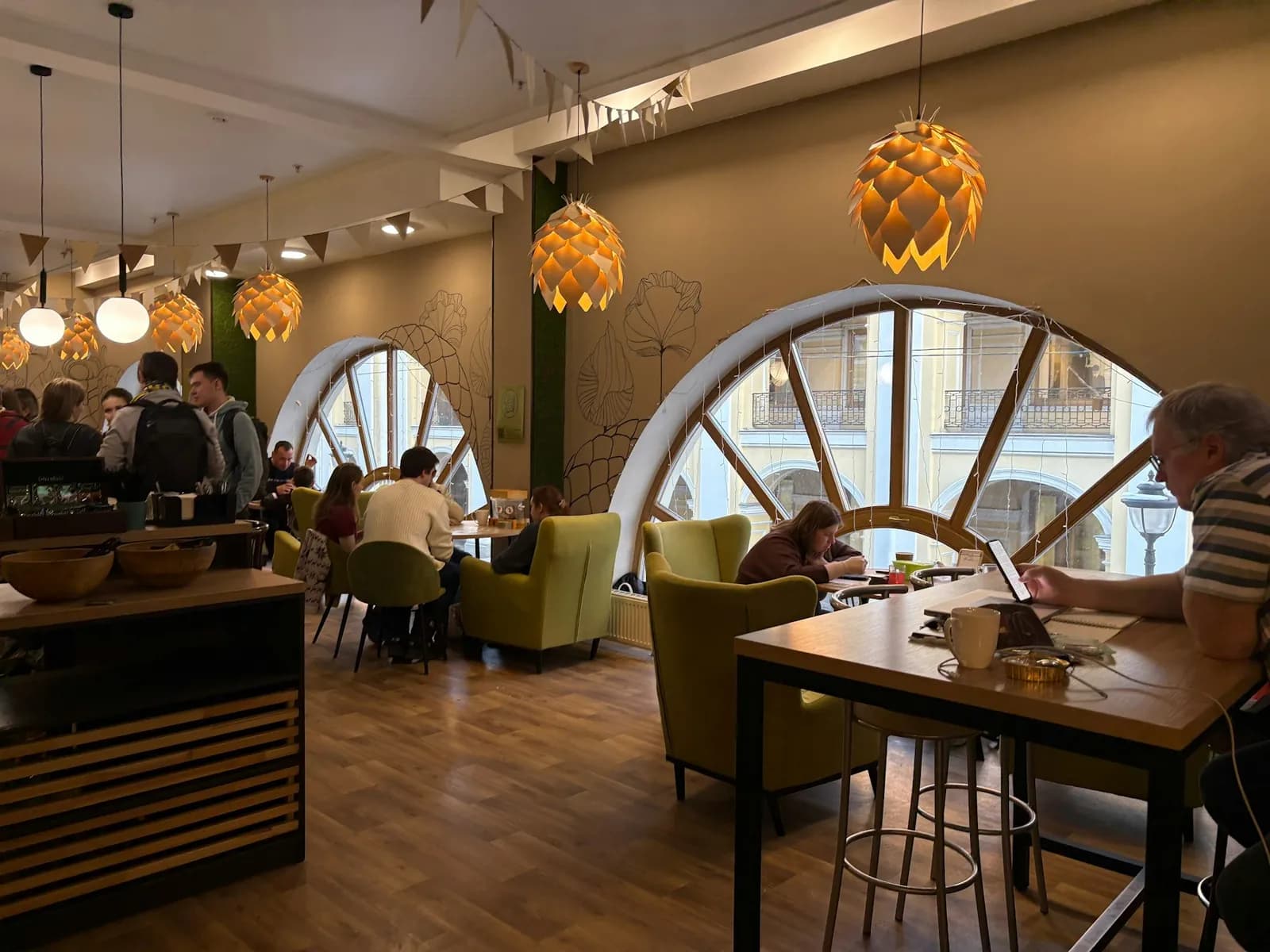 A coffee shop with tables by large windows